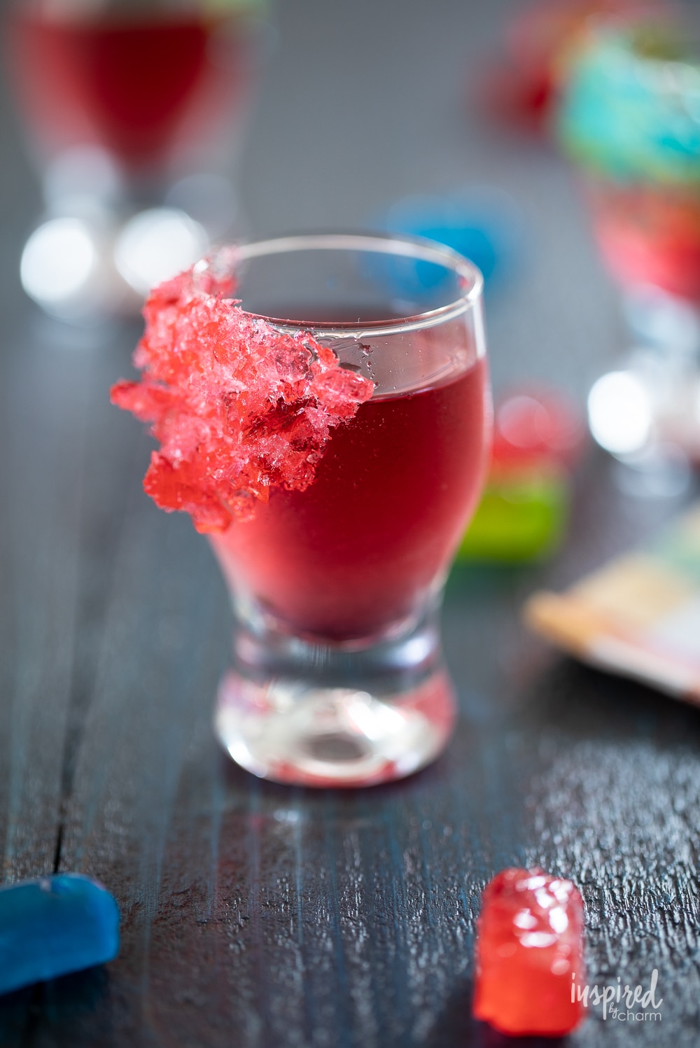 jolly rancher shot in glass with crushed candies on the side of the glass.