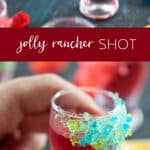 jolly rancher shot in glass with a hand holding one.