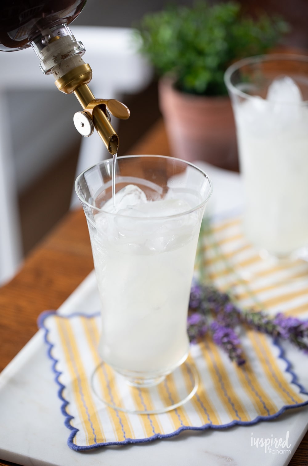 pouring lavender simple syrup into a glass of lemonade. 