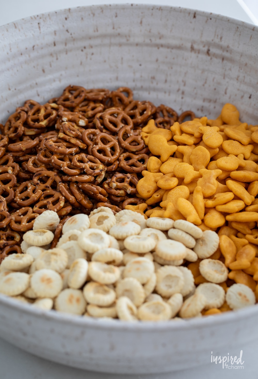 pretzels, goldfish crackers, and oyster crackers in a bowl. 