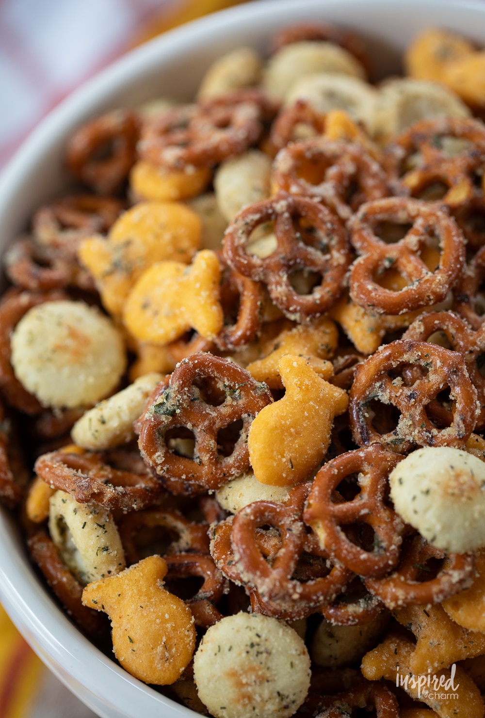 close up of ranch pretzel snack mix with goldfish and oyster crackers in a bowl.