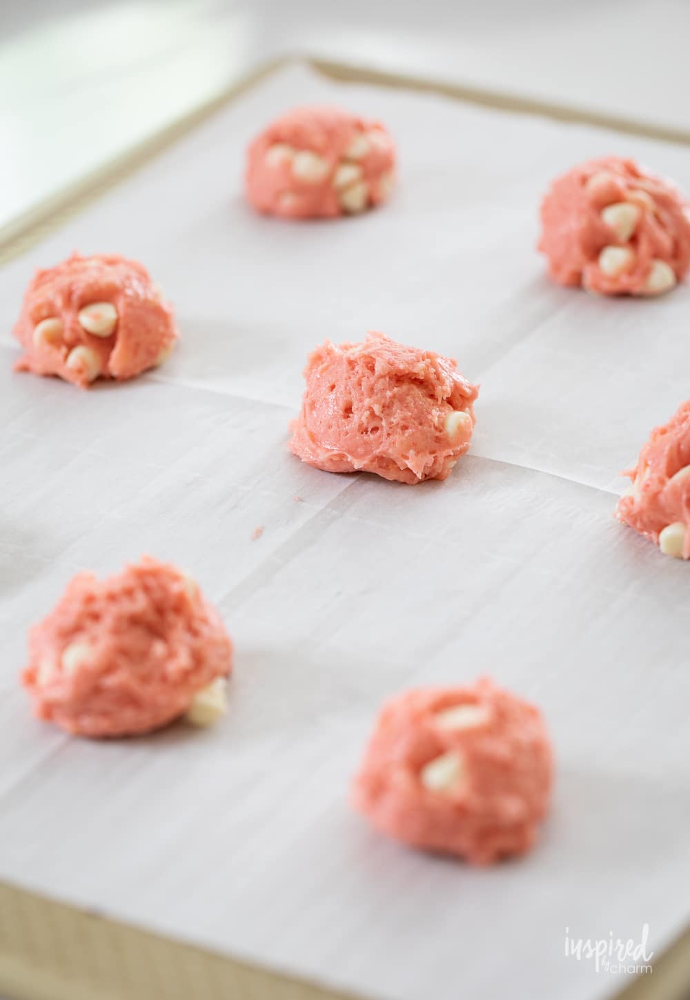 strawberry cake mix dough balls on a cookie sheet. 