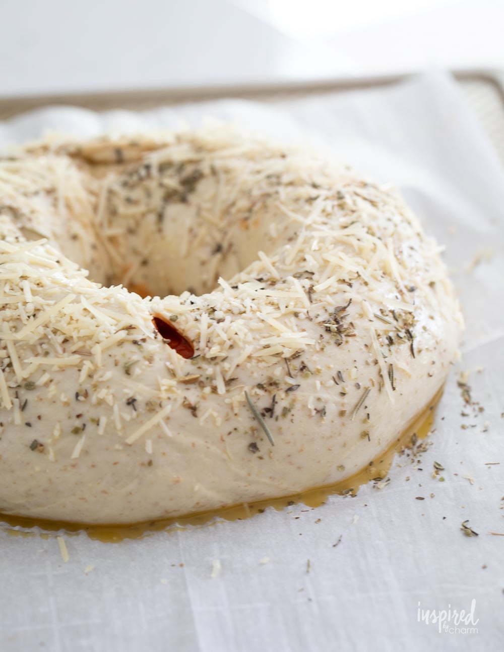 unbaked pizza ring sprinkled with herbs and parmesan cheese.