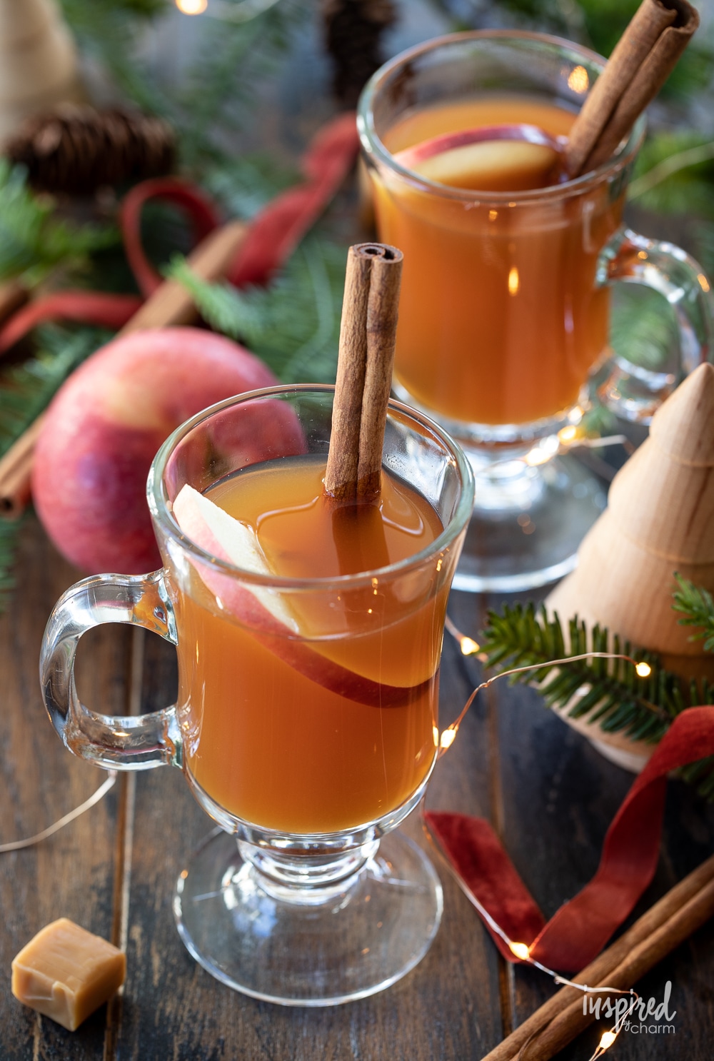 two glasses of spiked caramel apple cider tea in clear glass mugs.