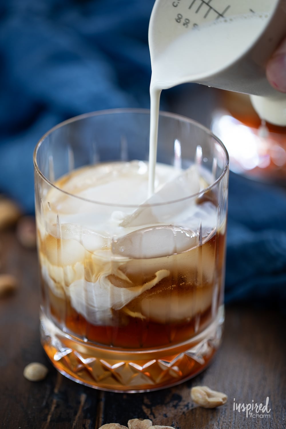 adding cream to a peanut butter white russian cocktail.