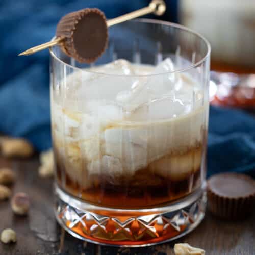 peanut butter white russian cocktail in a rocks glass with peanut butter cup garnish.