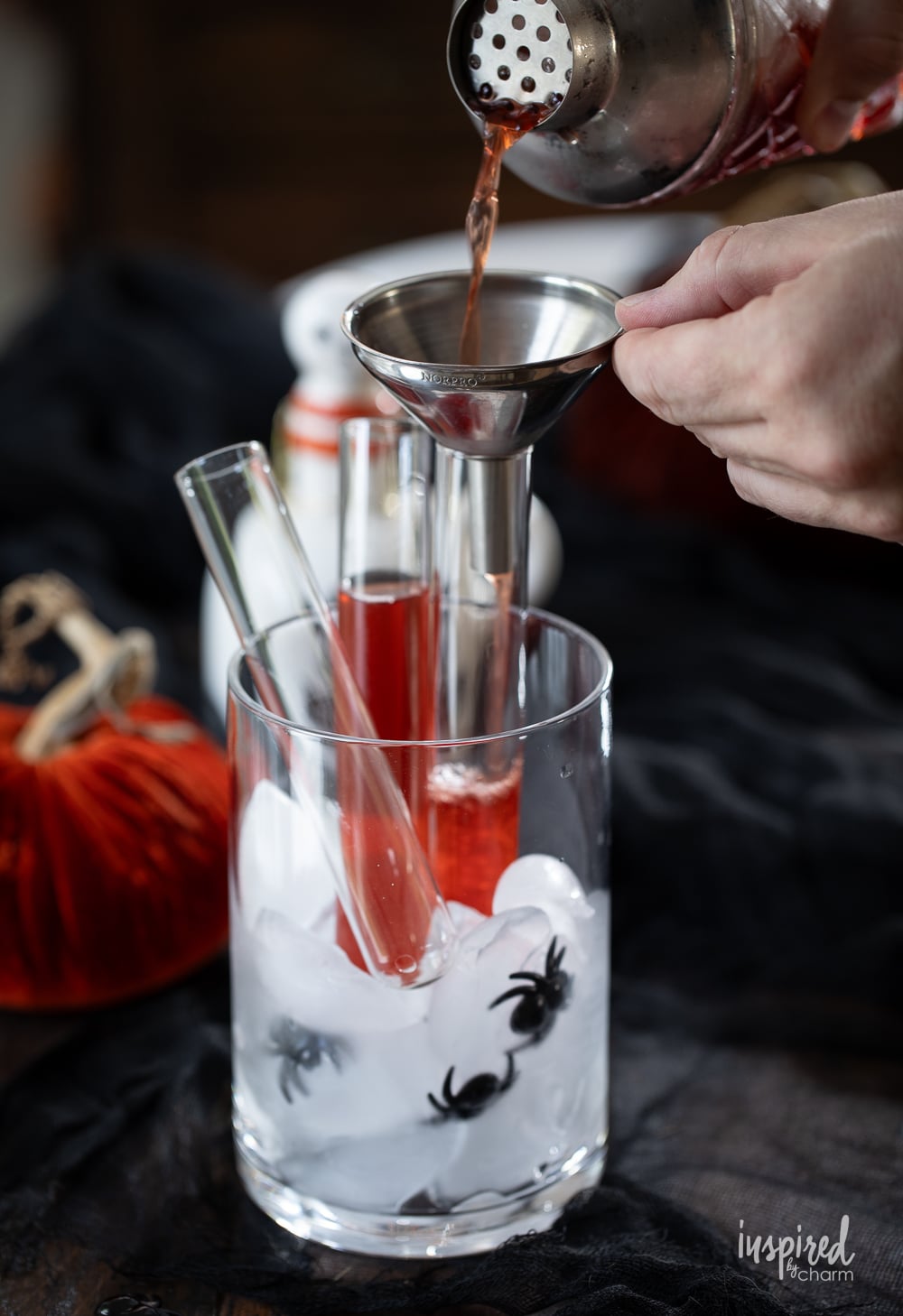 using a funnel to add a halloween shot into a glass vial.