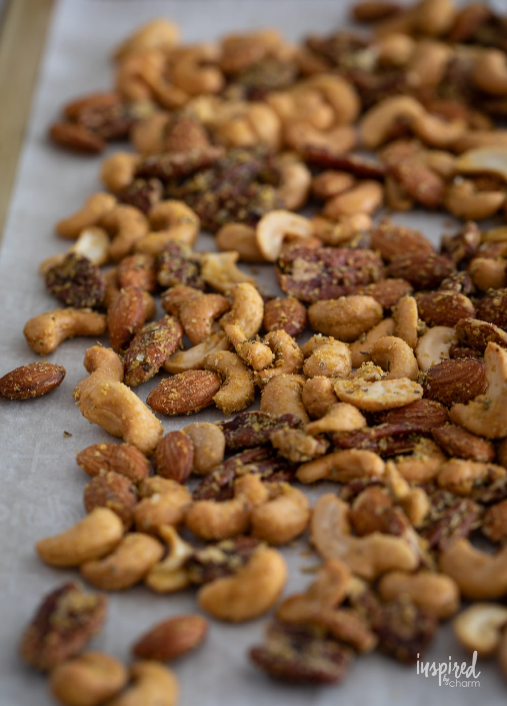 nuts for pizza trail mix spread out onto a baking sheet.