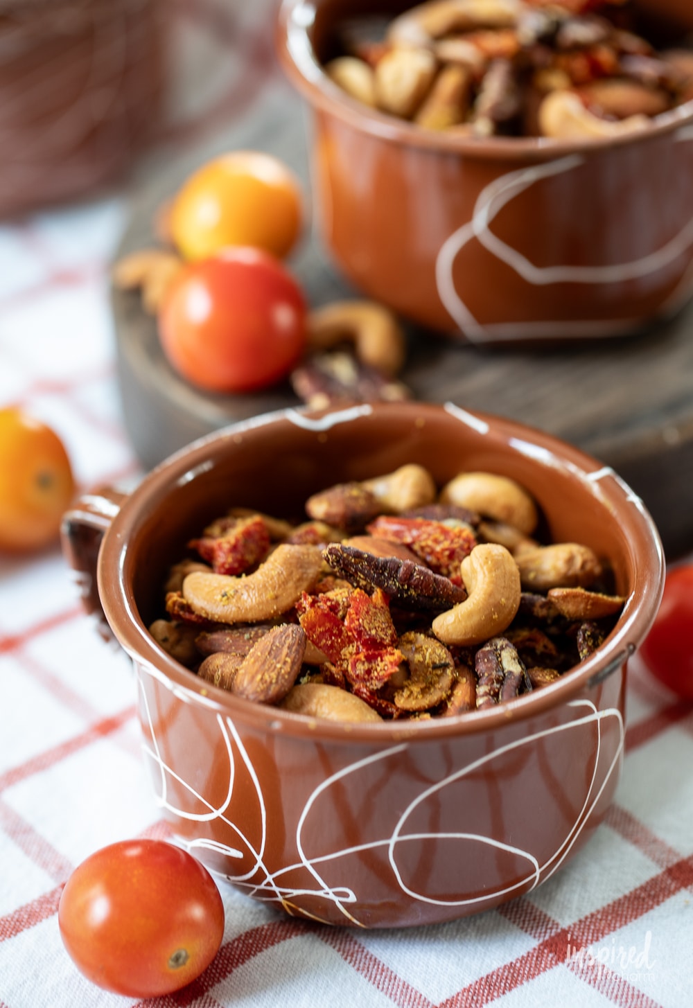 two enamel mugs filled with homemade pizza trail mix.