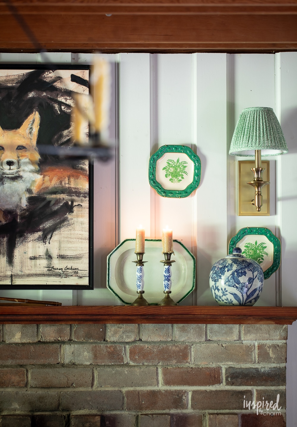 cozy cottage mantel with sconces and vintage plates hung on the wall. 
