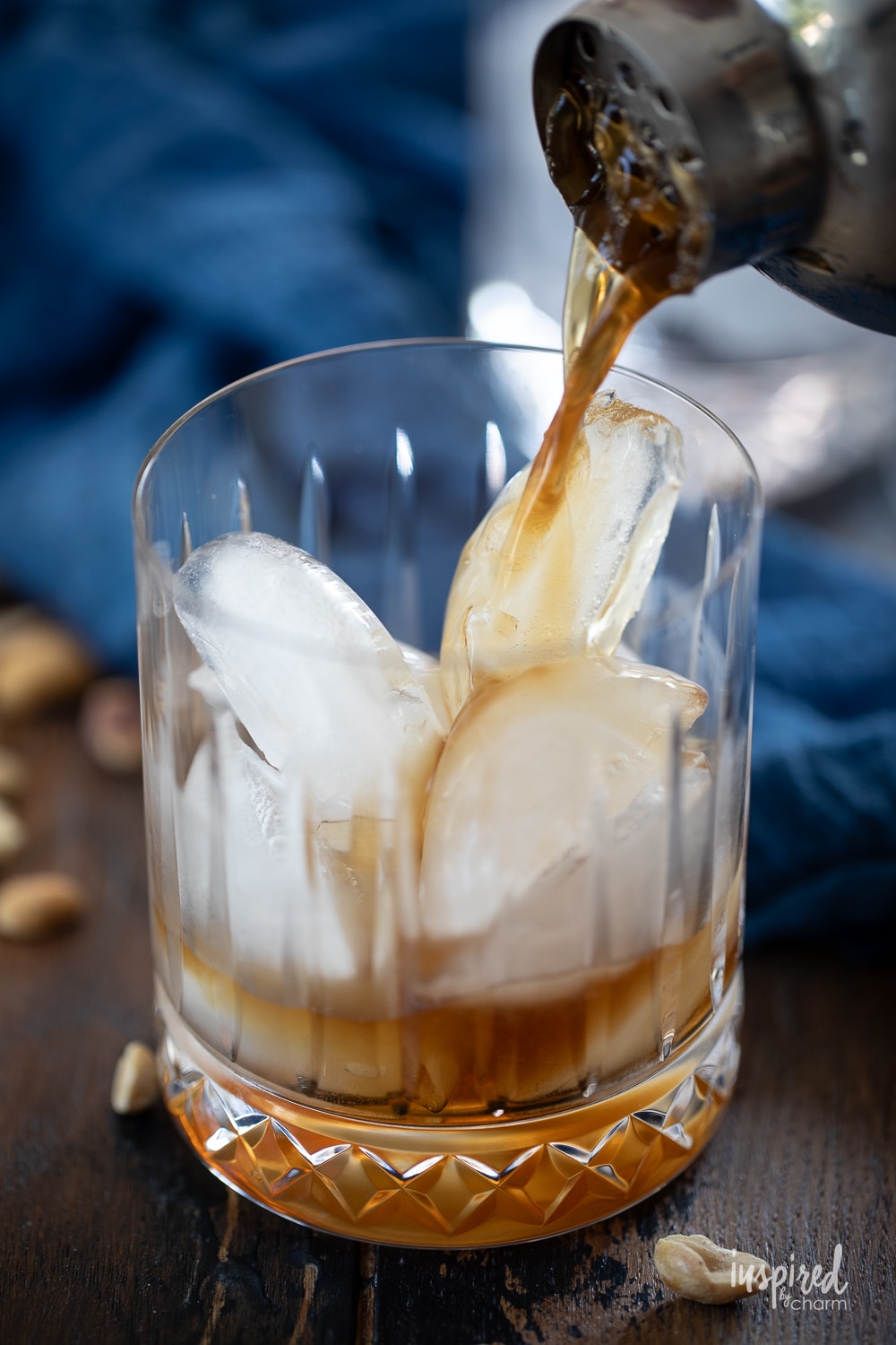 pouring peanut butter white russian cocktail in a rocks glass with ice.