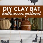 a diy halloween bat garland with gold chain hung on a mantel.
