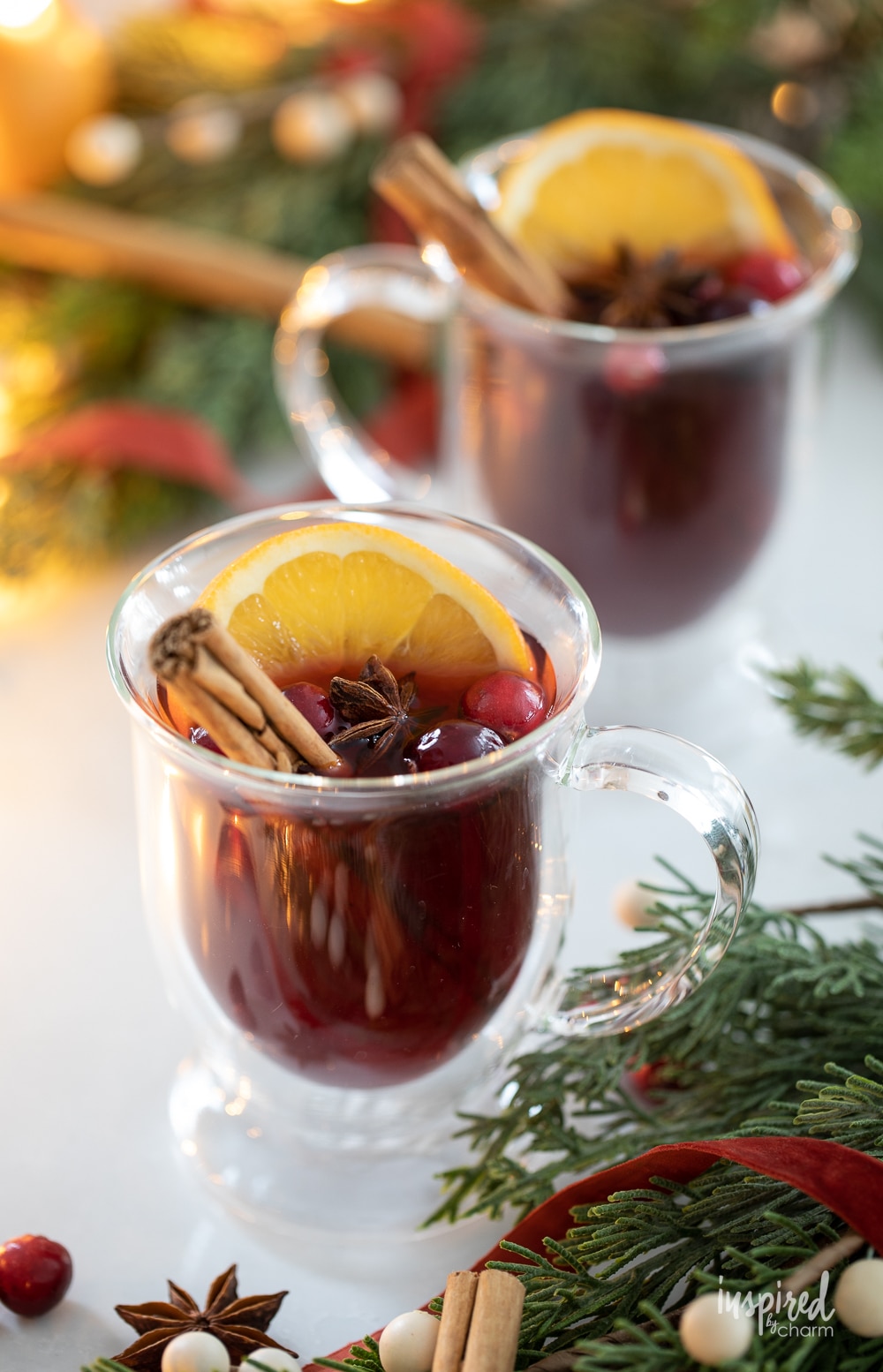 spiced cranberry hot toddies garnished with cinnamon sticks in a festive setting. 