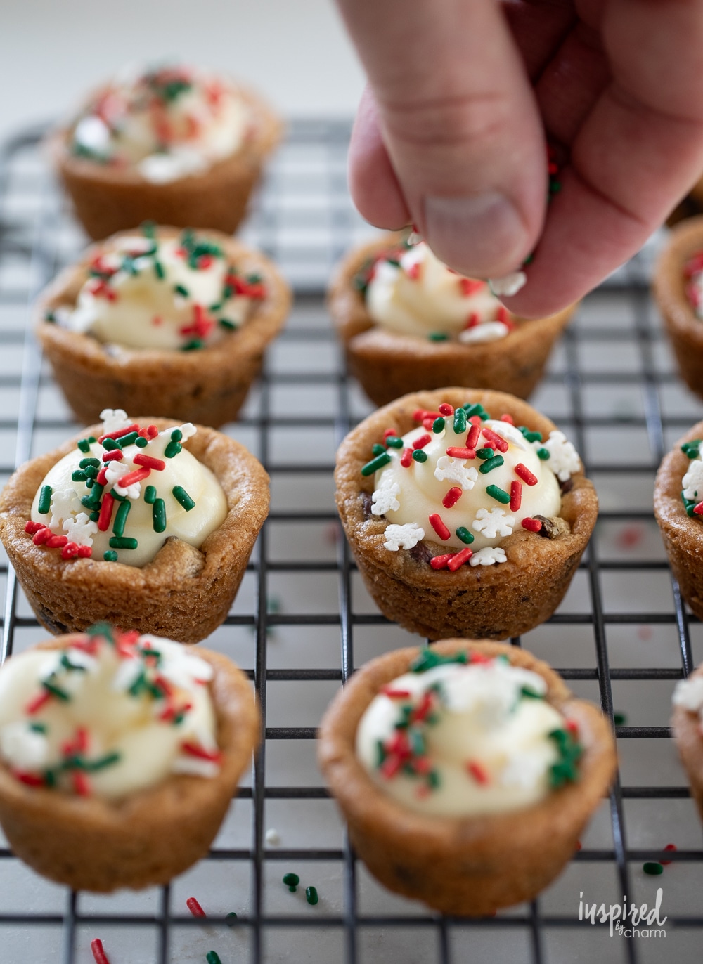 adding sprinkles wot cheesecake cookie cups.