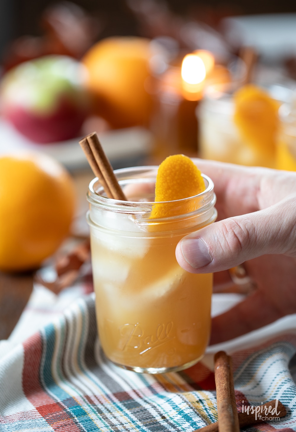 hand holding apple cider whiskey cocktail. 