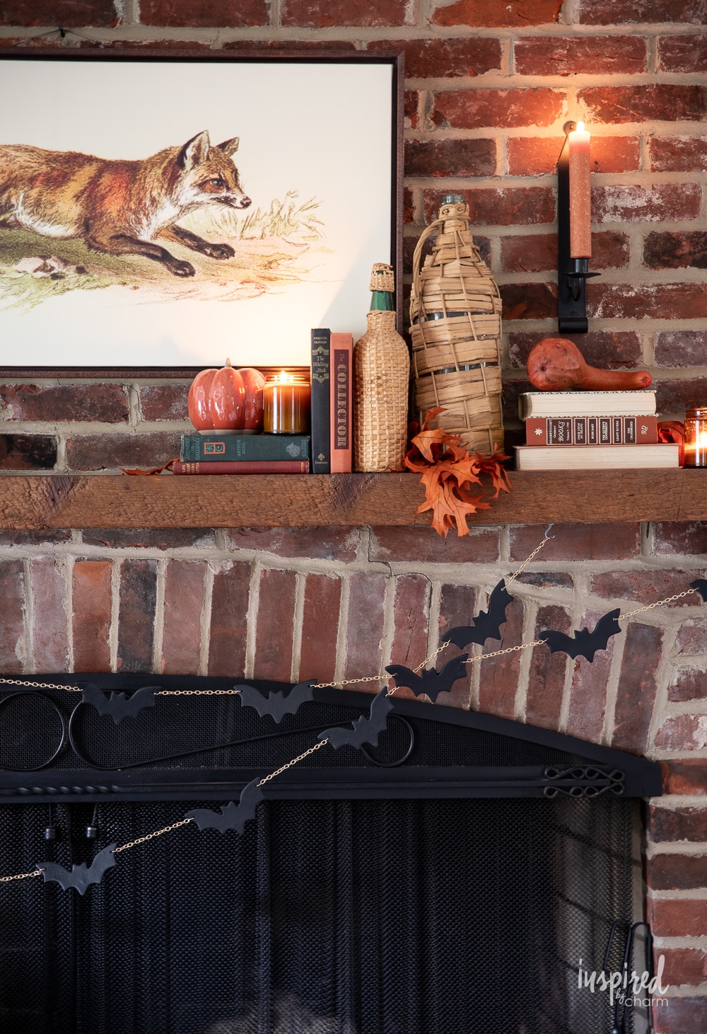 brick fireplace mantel decorated for fall with DIY bat garland.