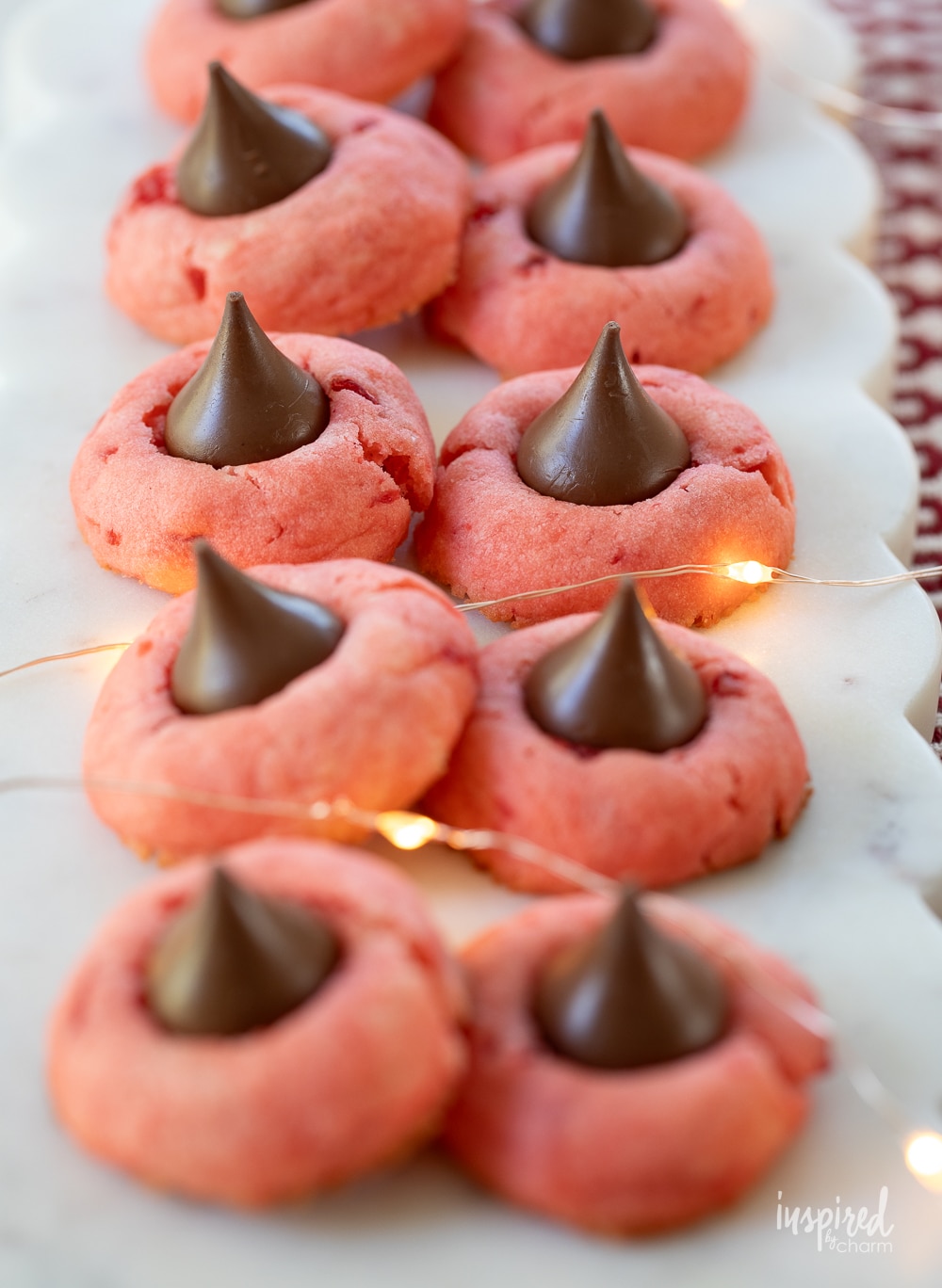 cherry cookies stacked up on marble plate.