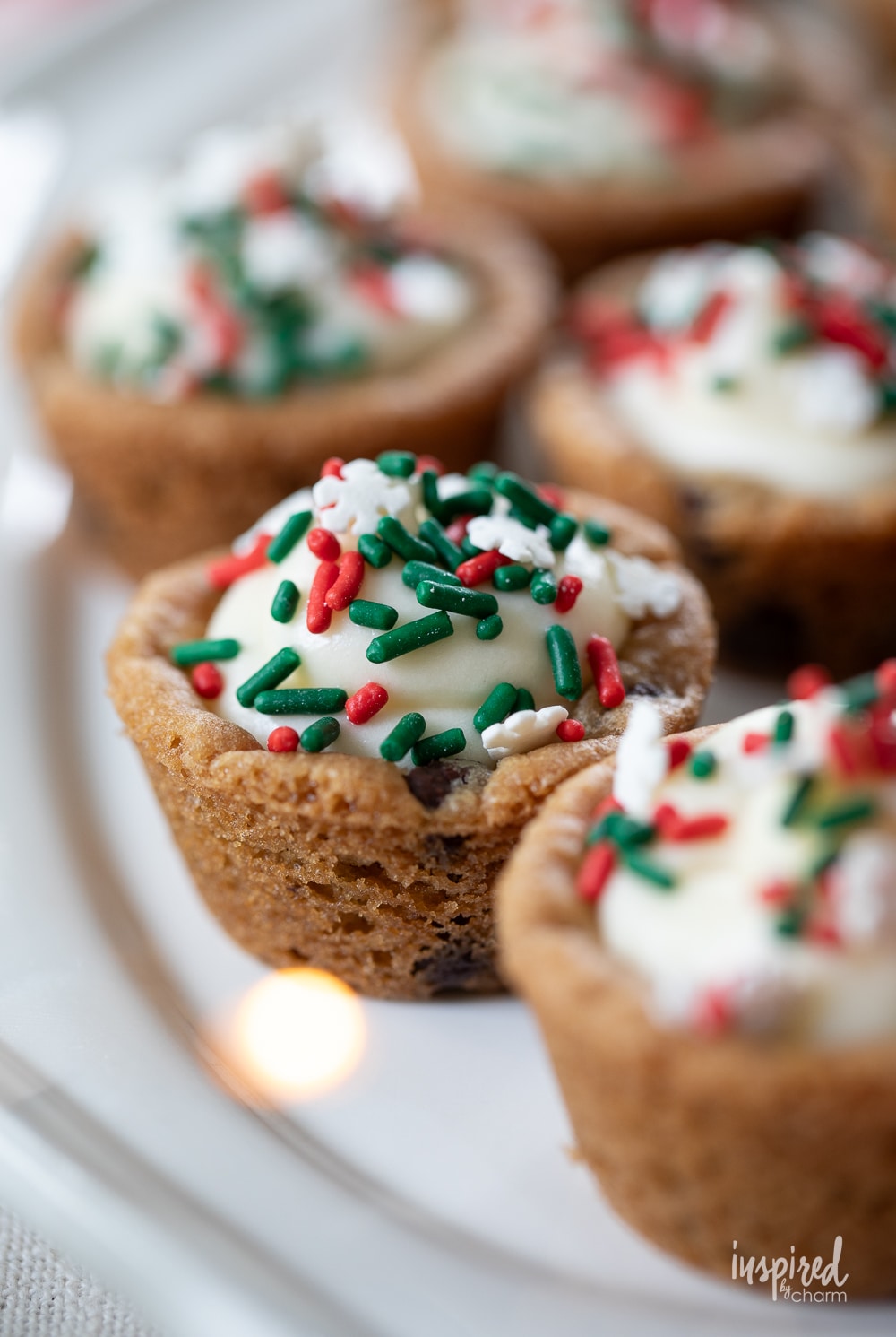 cookie cups filled with cheesecake and red and green sprinkles.