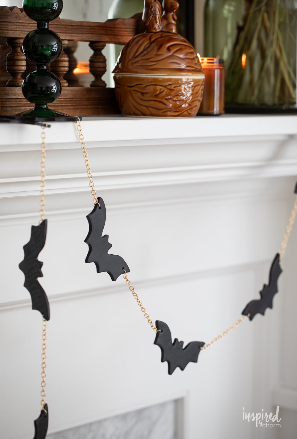 black bat and gold garland hung on a mantel.