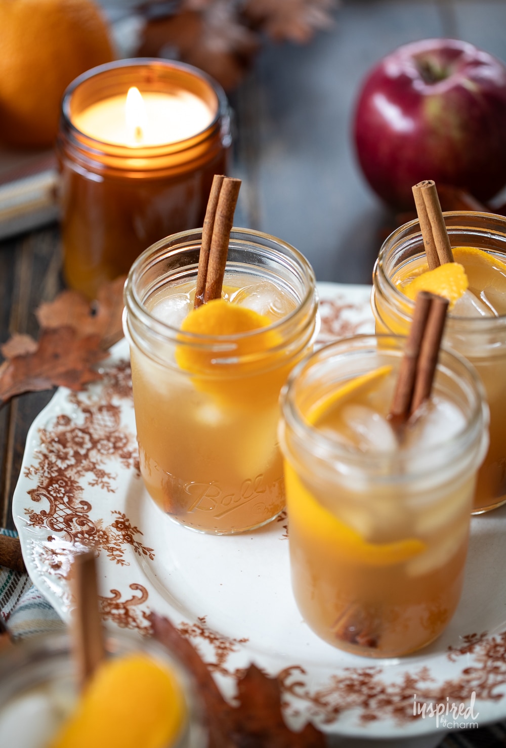 three apple cider whiskey sours on a vintage plate.