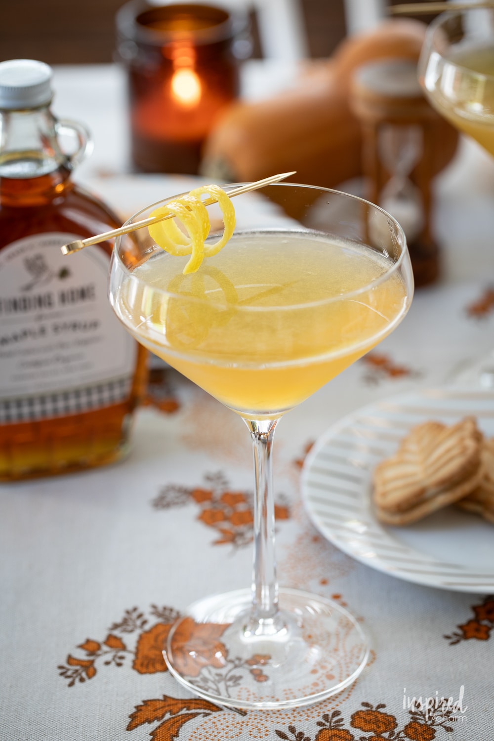 maple martini served in a glass with a lemon twist. 