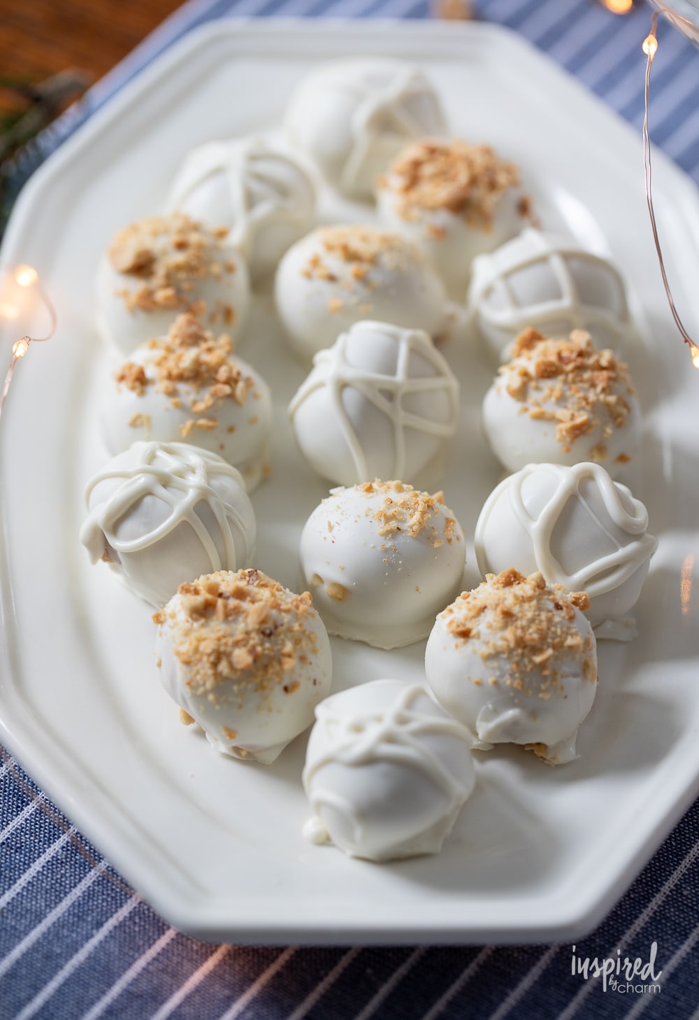 white chocolate and peanut butter truffles served on a white platter.