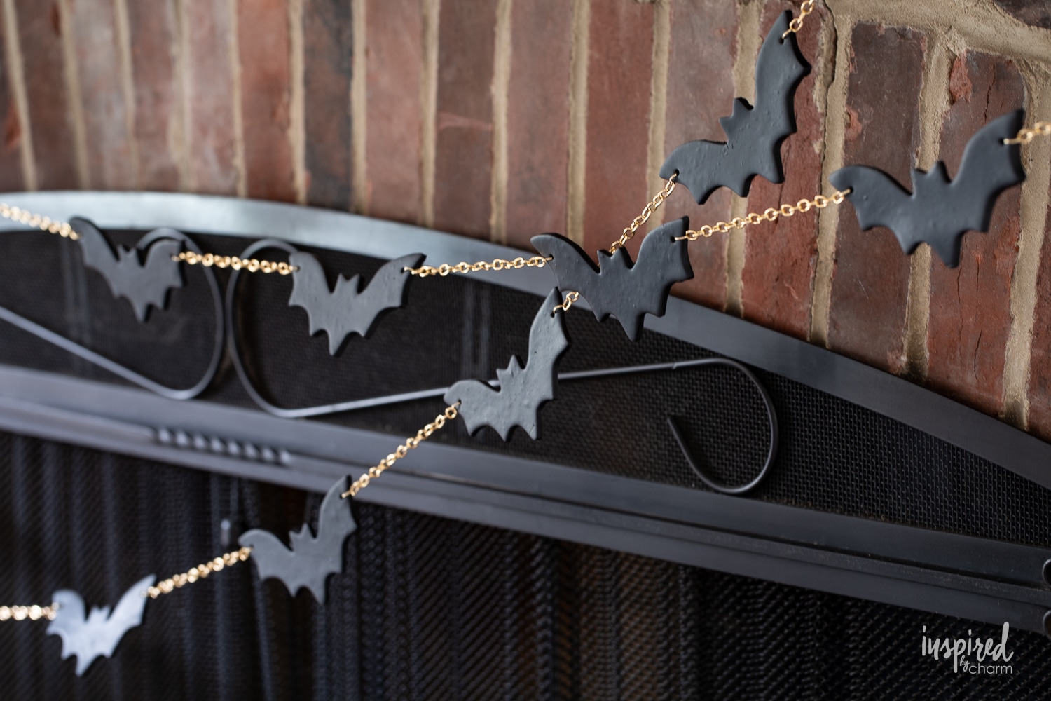 halloween bat garland DIY hung on a brick fireplace.