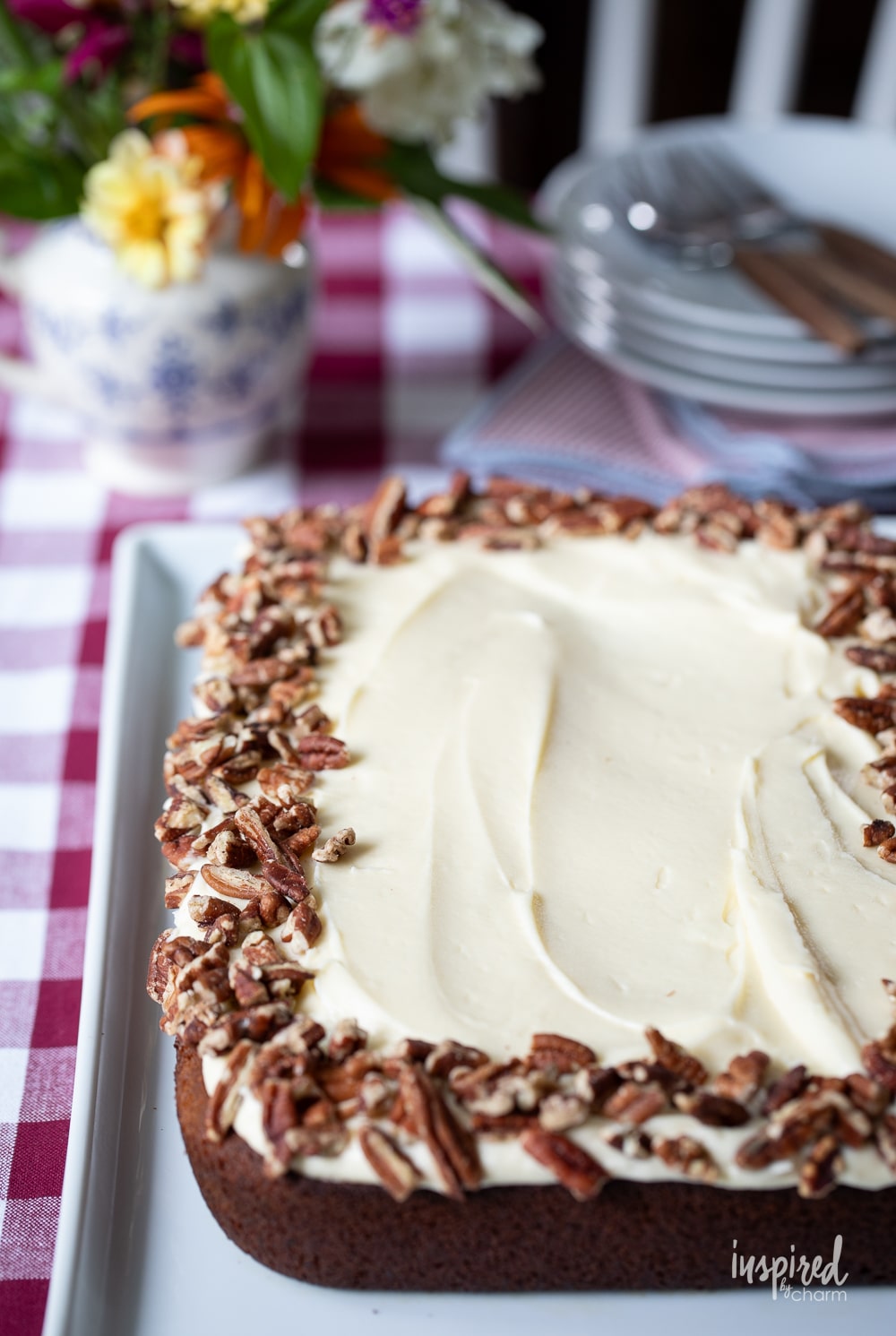 whole sweet potato cake topped with cream cheese frosting and pecans. 