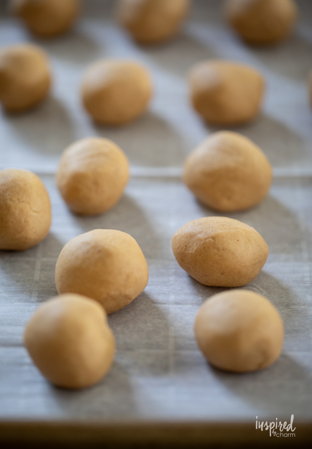 peanut butter truffles rolled into a ball on a baking sheet. 