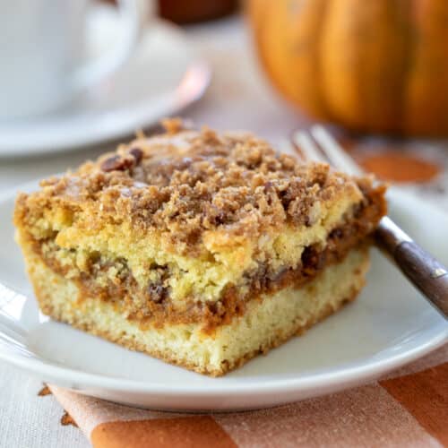 pumpkin swirl coffee cake on a white plate with a fork.
