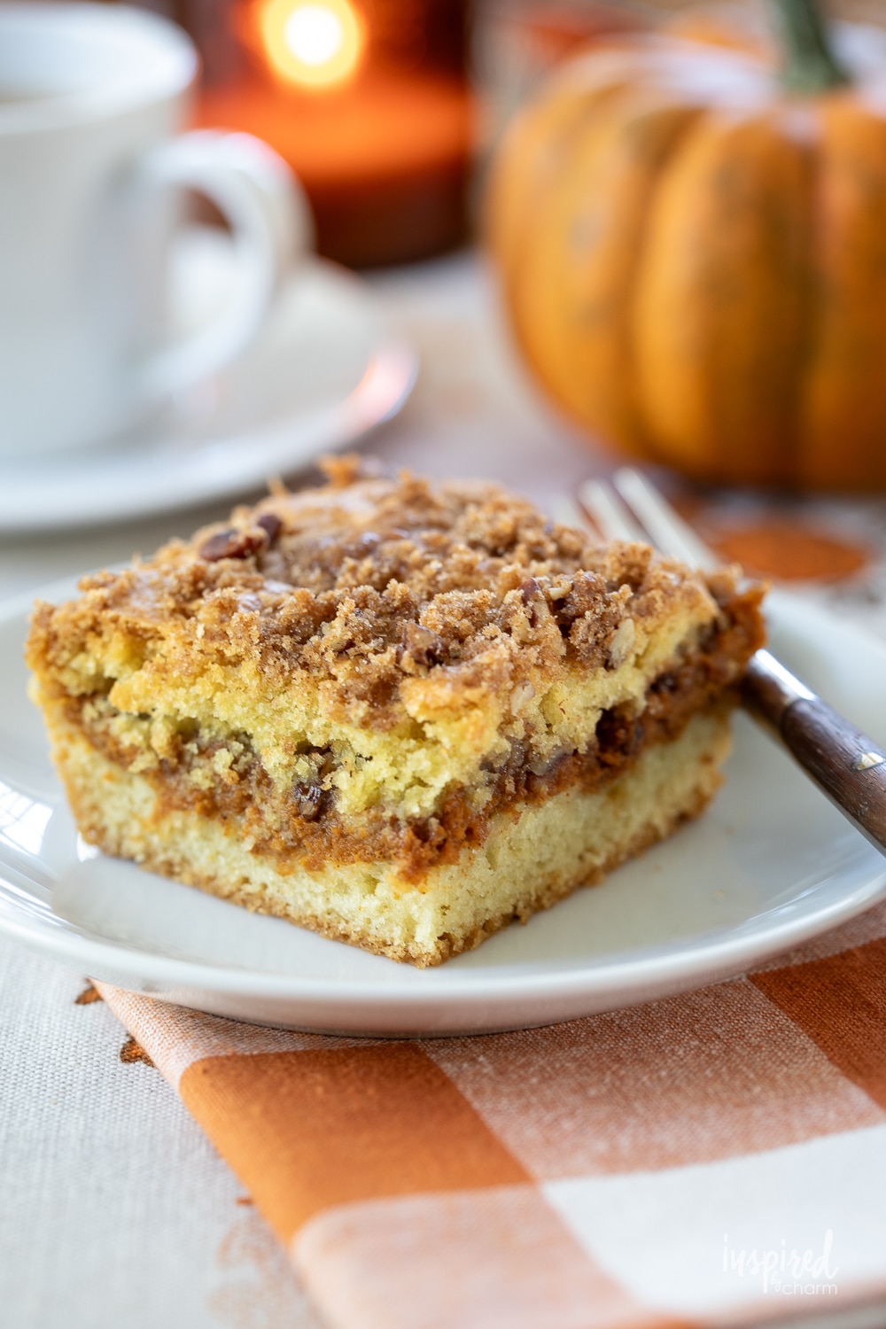 pumpkin swirl coffee cake on a white plate with a fork.