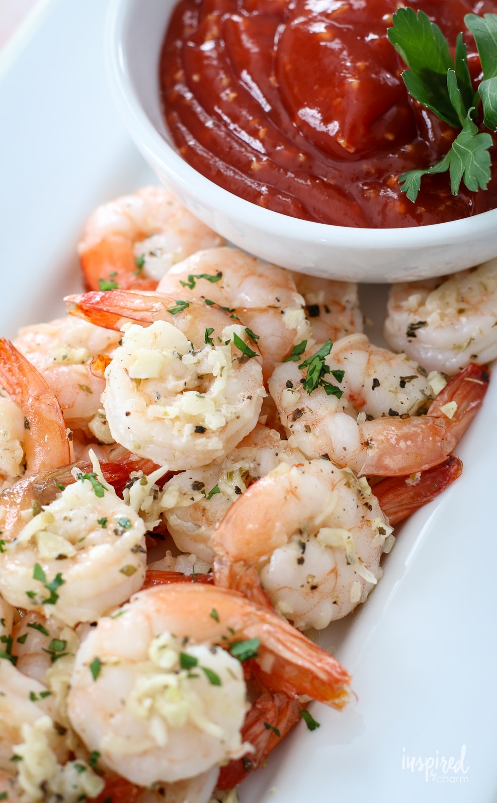 parmesan roasted shrimp on a plate with cocktail sauce in a bowl.
