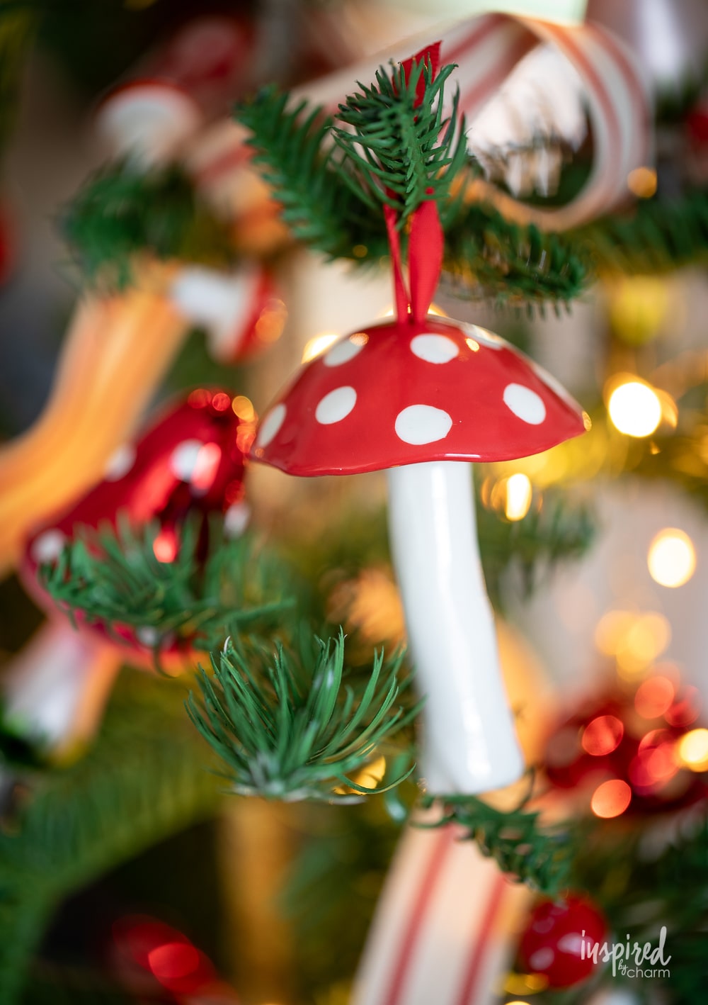 ceramic mushroom ornament hung on a christmas tree.