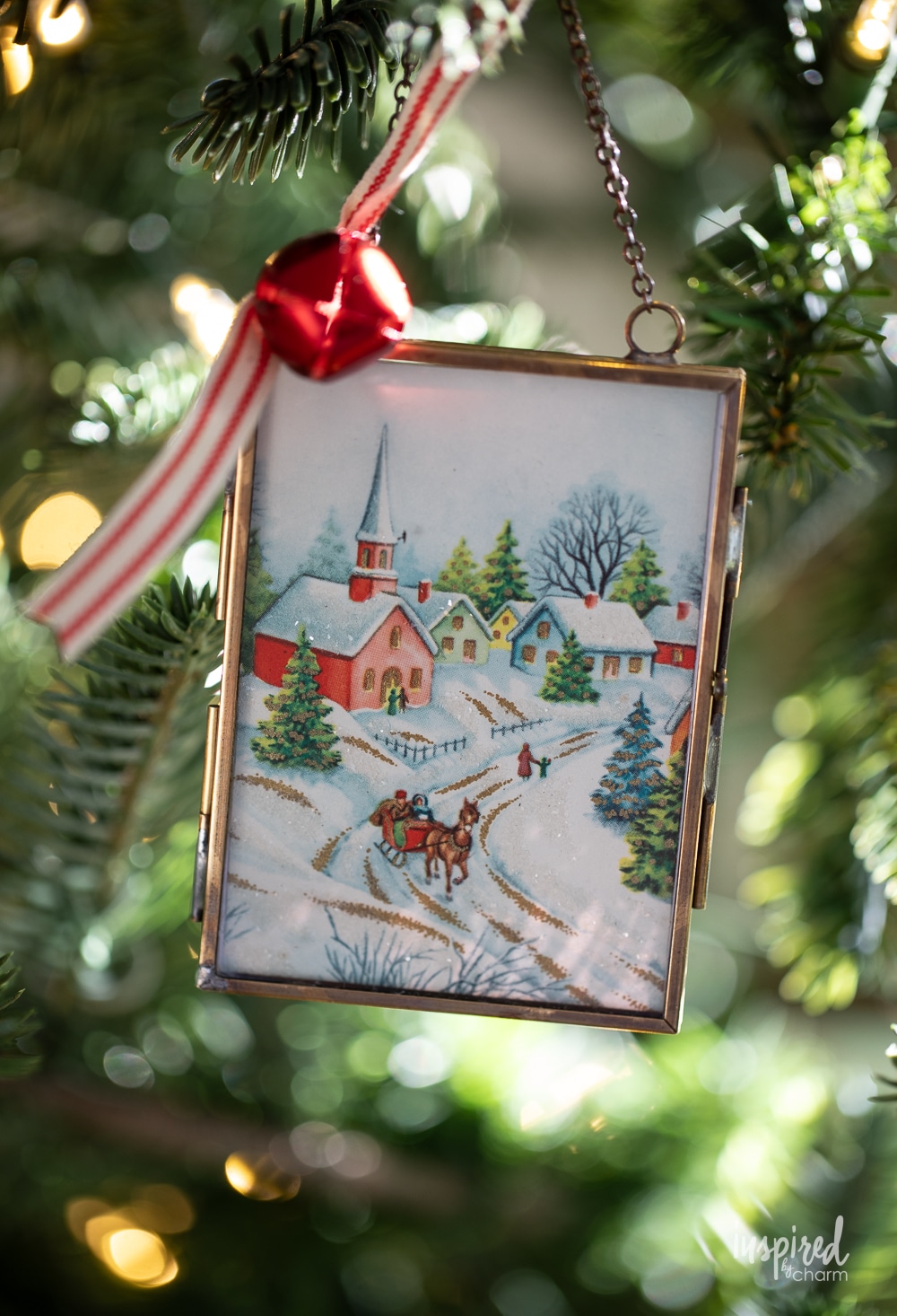 vintage christmas card in a glass ornament frame holder on a tree.
