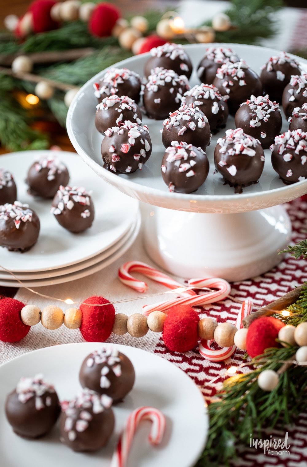 an array of peppermint Oreo truffles on a cake stand and served on small plates.
