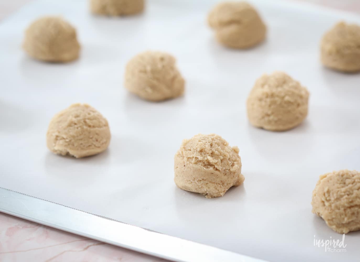 balls of cookie dough on a cookie sheet.