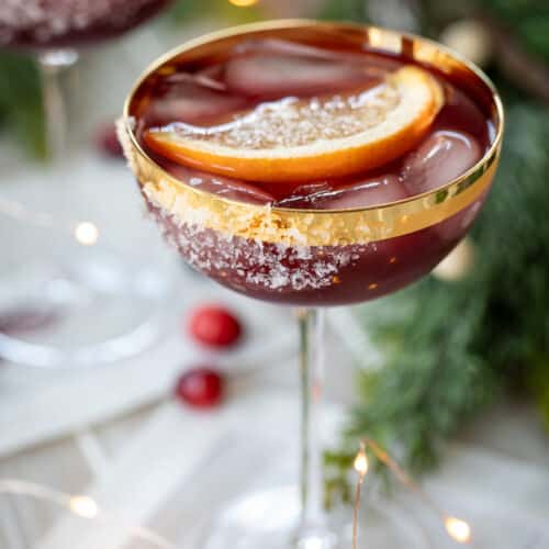 mulled wine margarita in a gold rimmed coupe glass.
