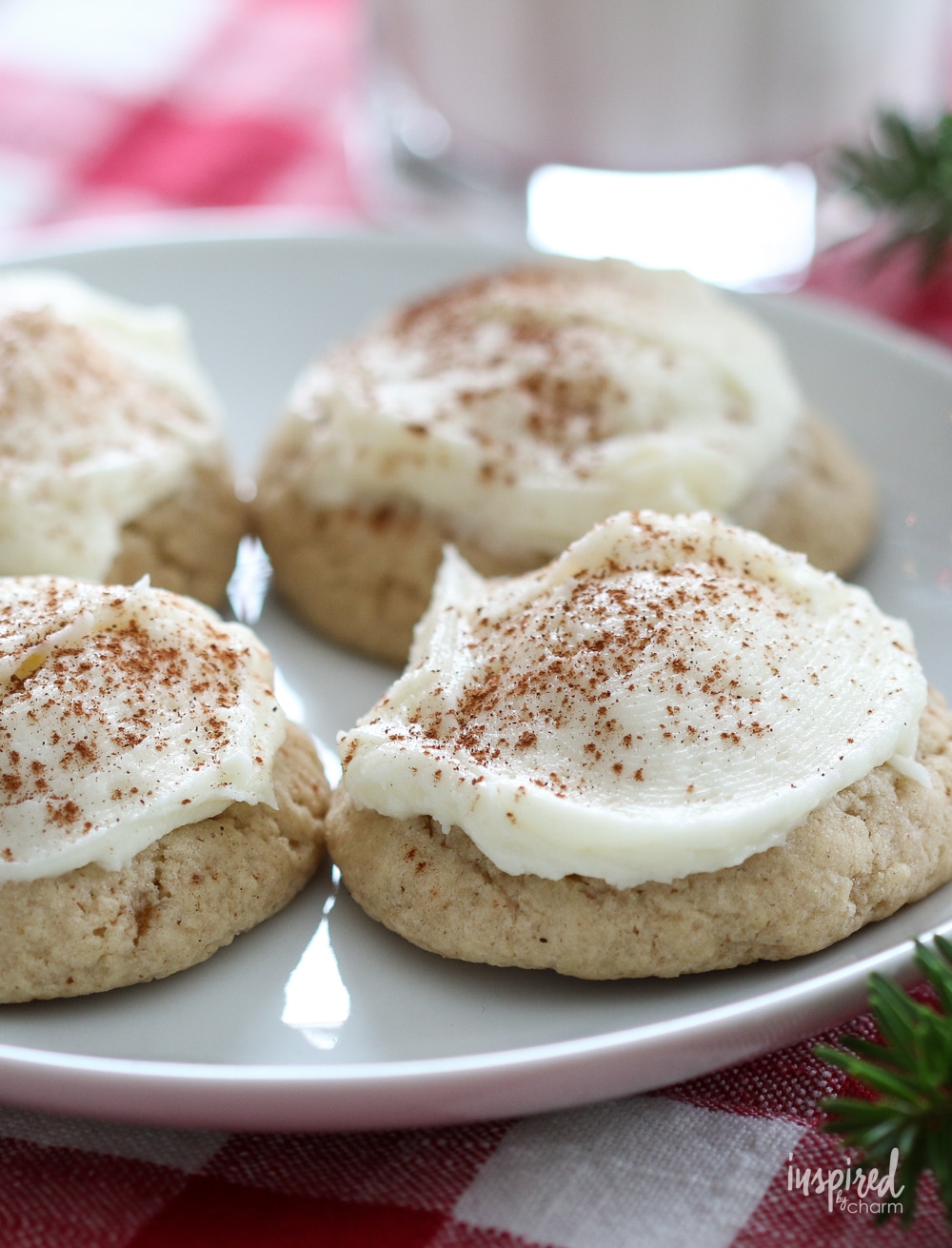 four frosted eggnog cookies on a plate.