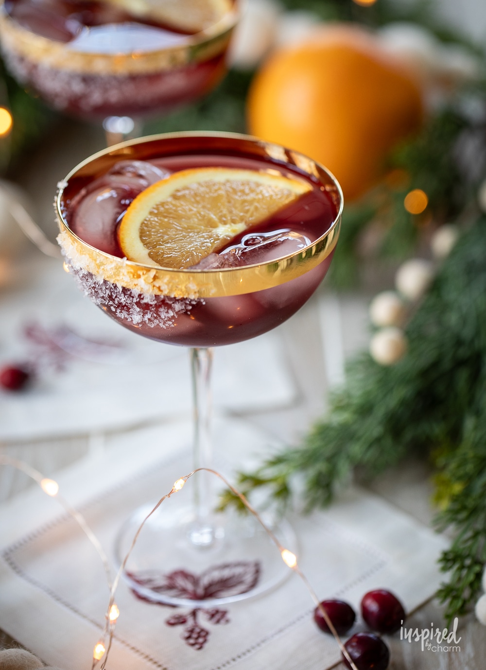 christmas mulled wine margarita in a glass with orange garnish. 