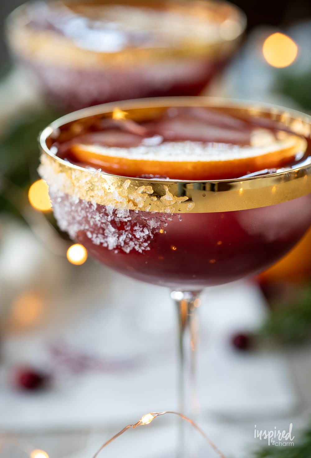 festive mulled wine margarita in coupe glass with salted rim.