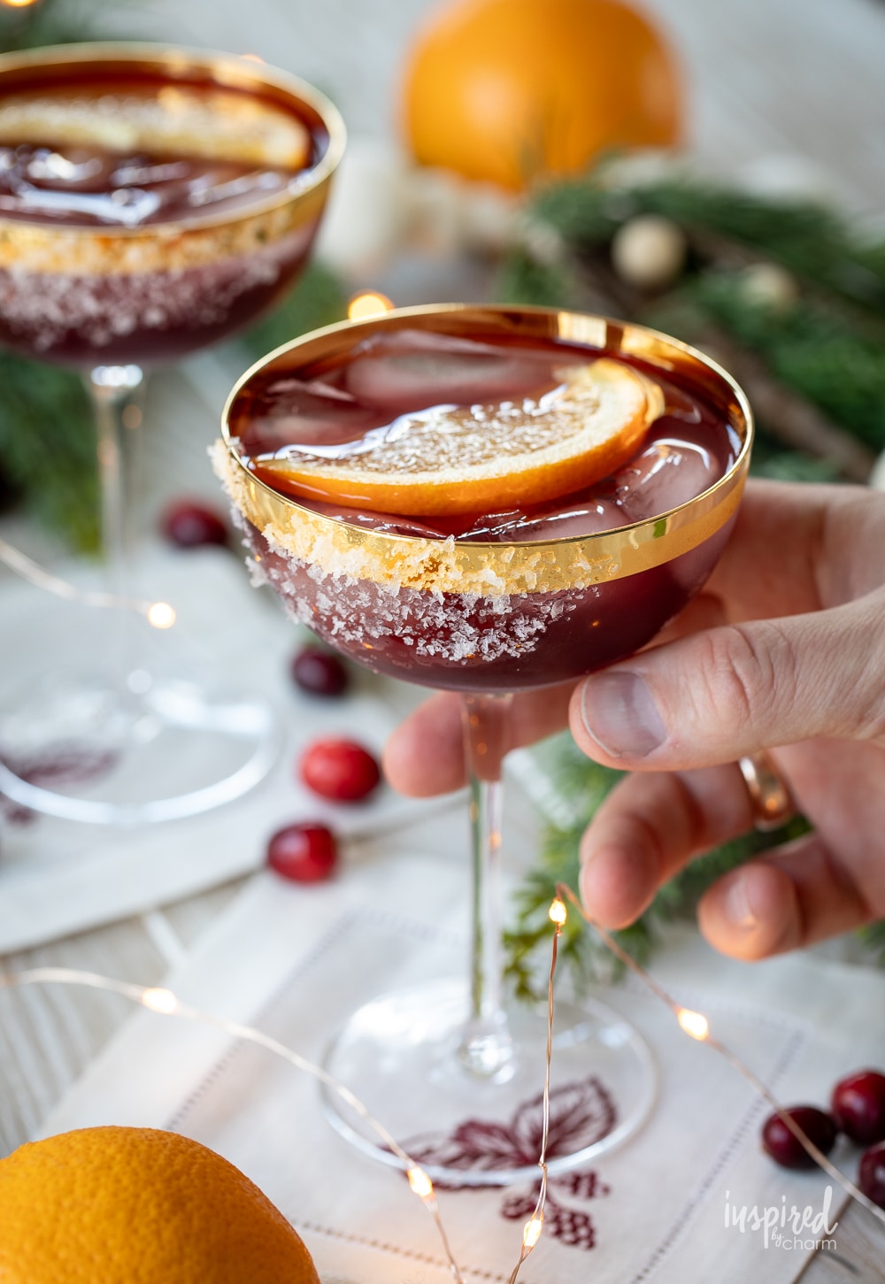 hand holding a mulled wine margarita in a coupe glass.