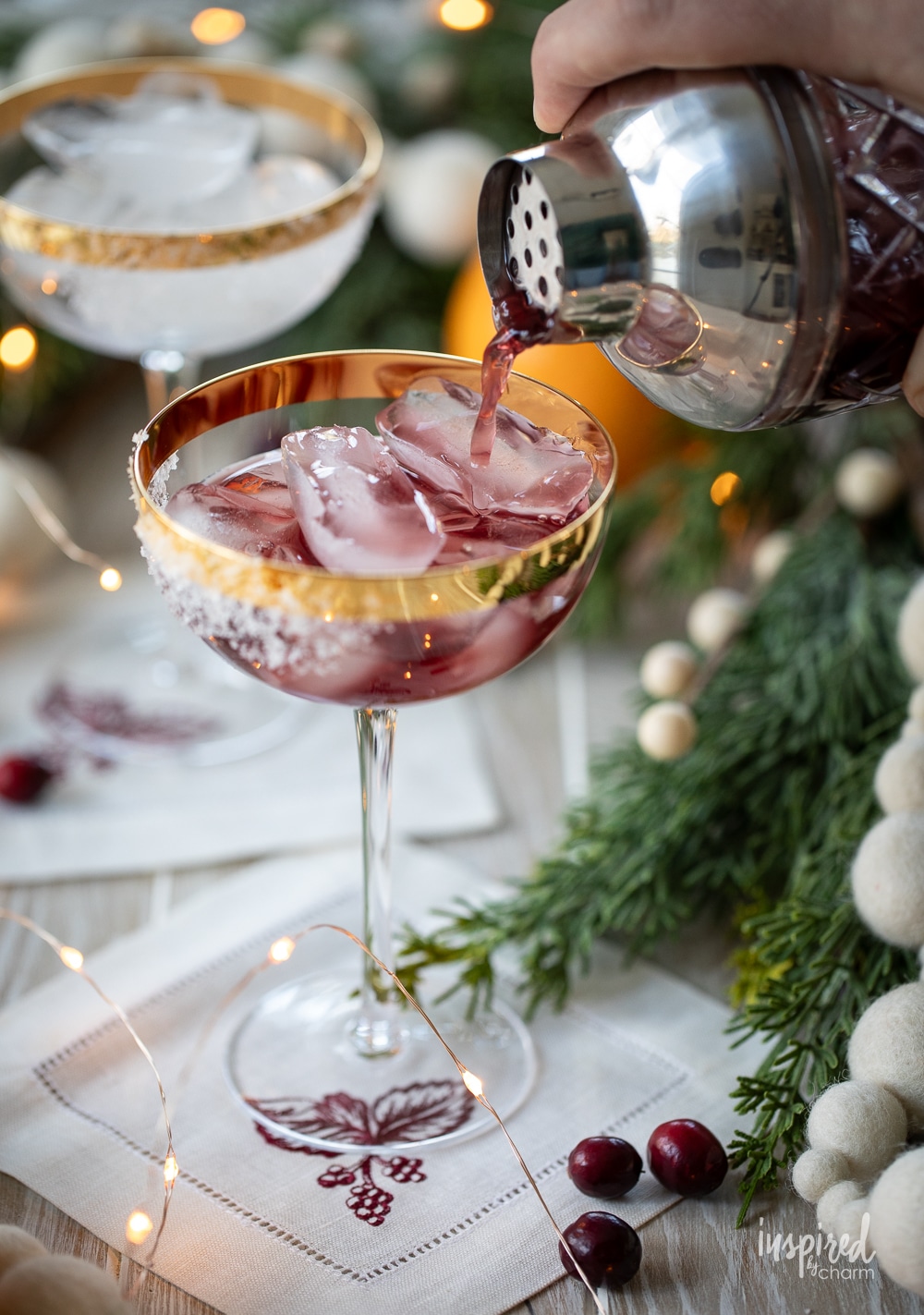 pouring a mulled wine margarita into a festive coupe glass. 