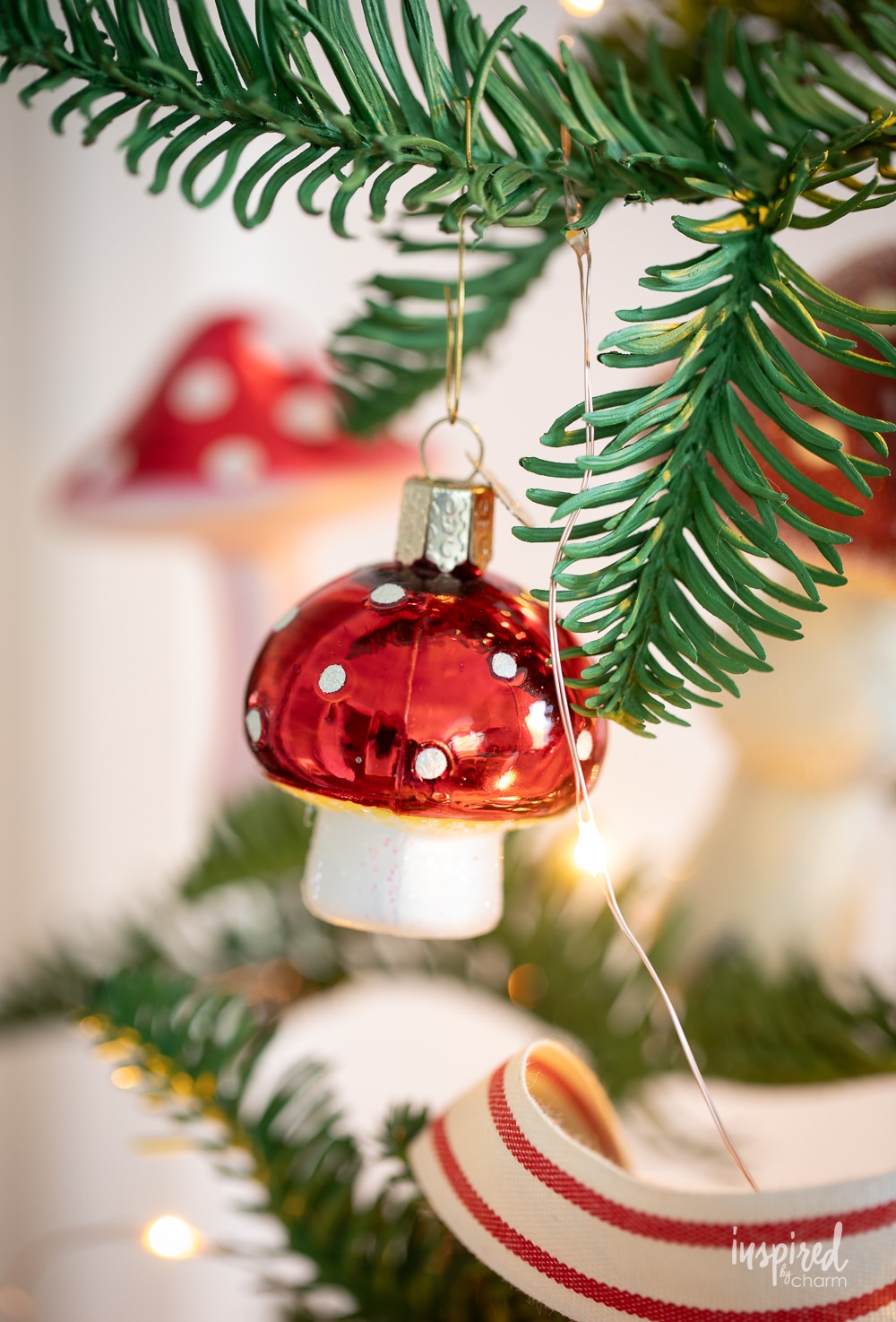 small mushroom ornament hung on a christmas tree.