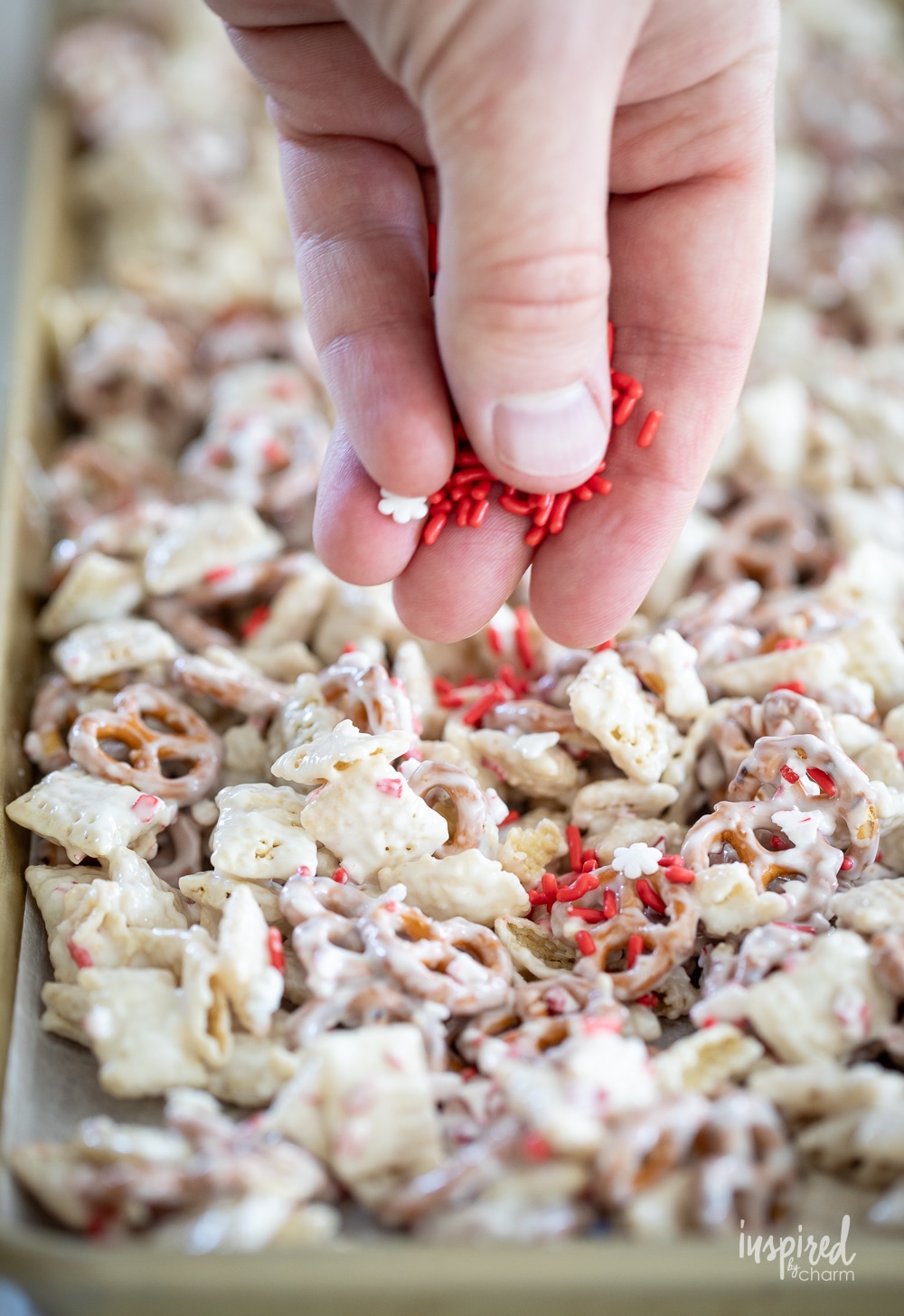 adding sprinkles to peppermint white chocolate chex mix.
