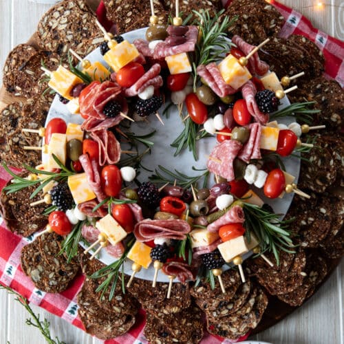 antipasto skewers arranged in a wreath shape surrounded by crackers.