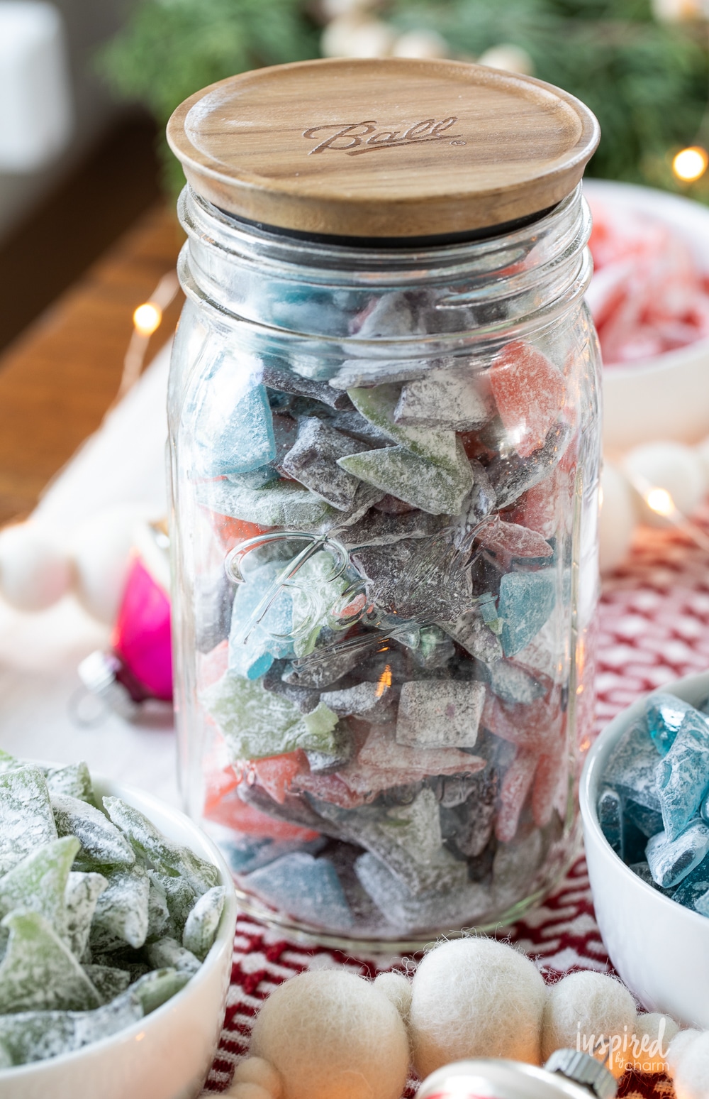 large glass jar with wood lid filled with colorful hard tack candy.