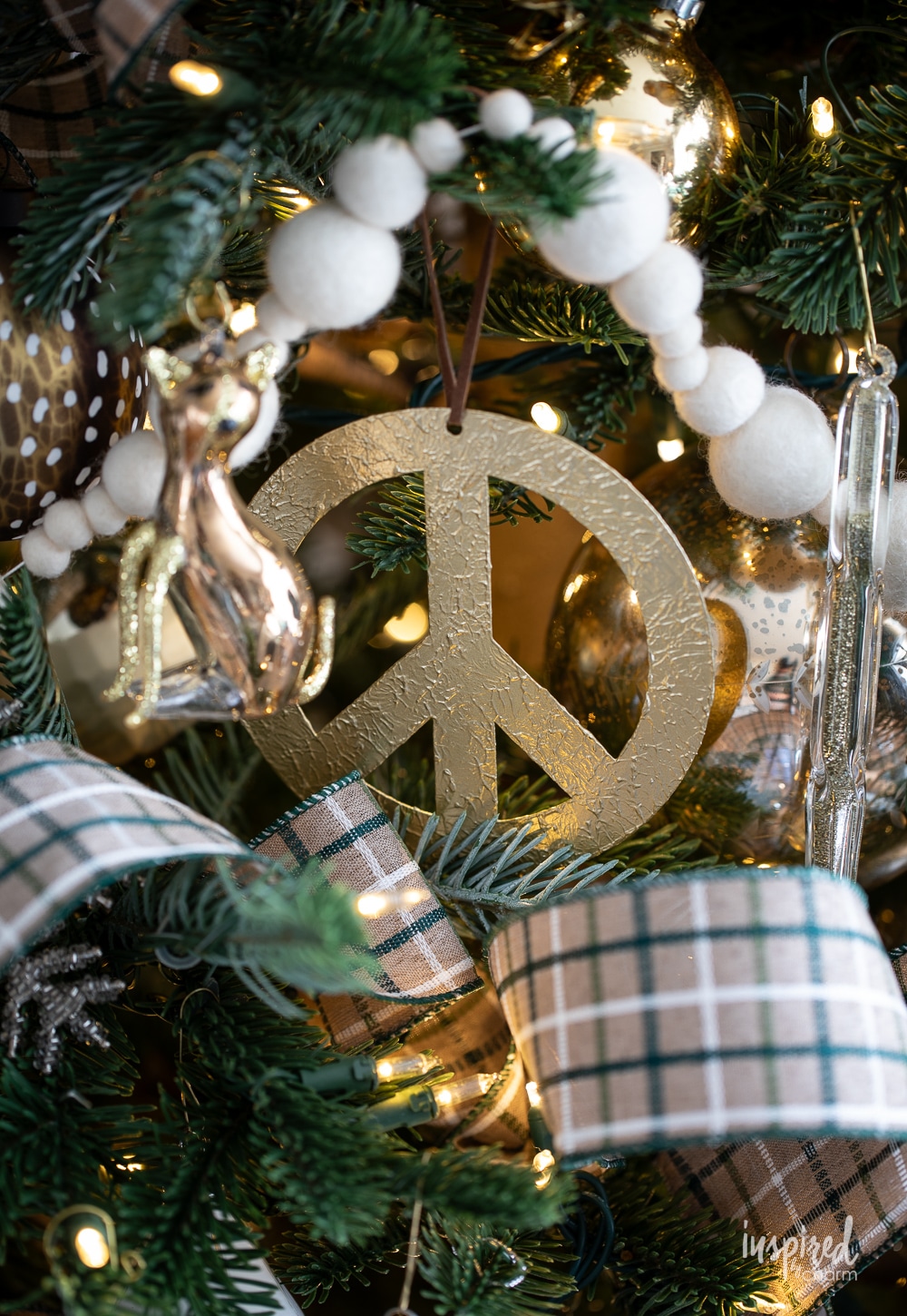 gold peace sign ornament on a christmas tree.