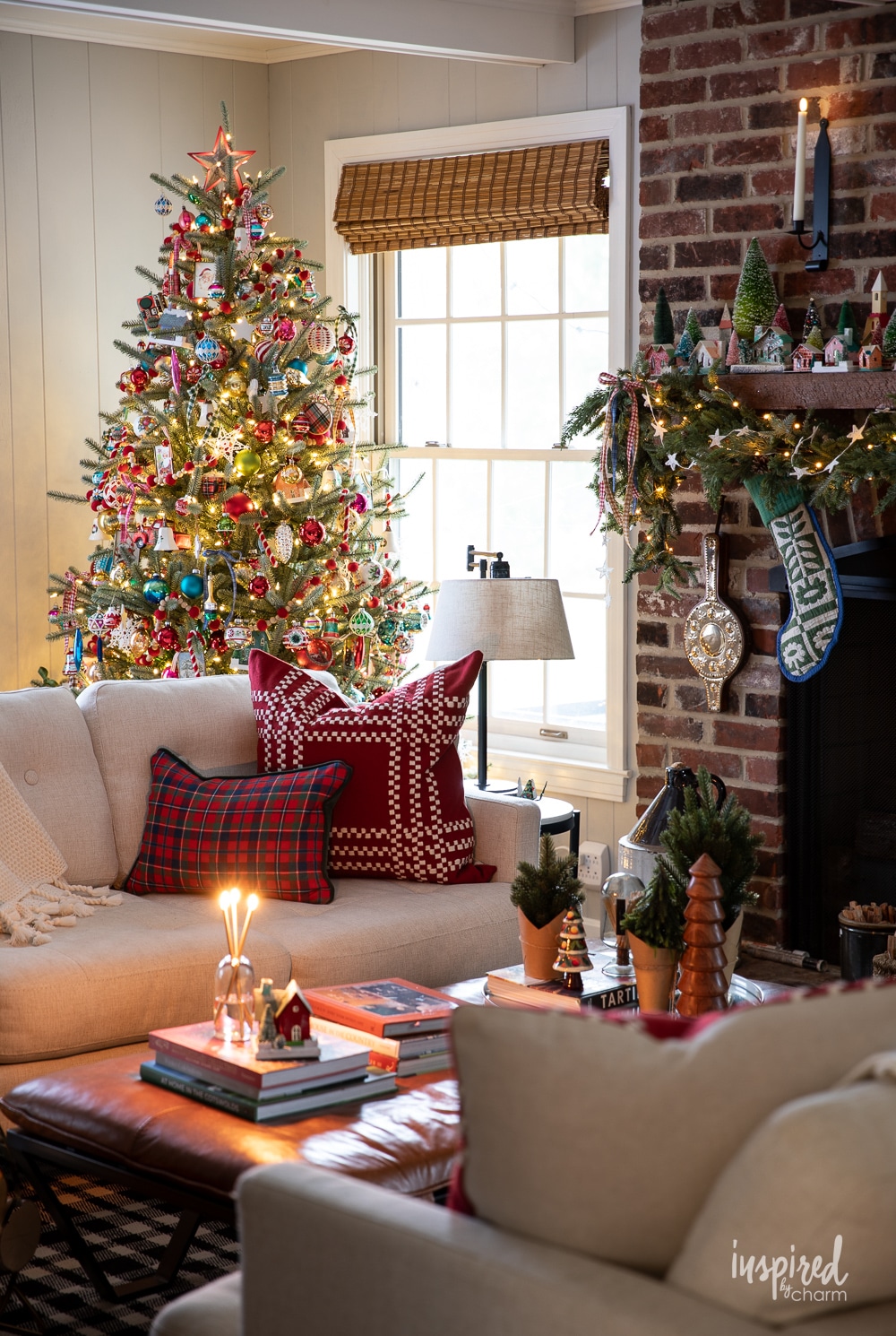 christmas tree in living room with brick fireplace. 