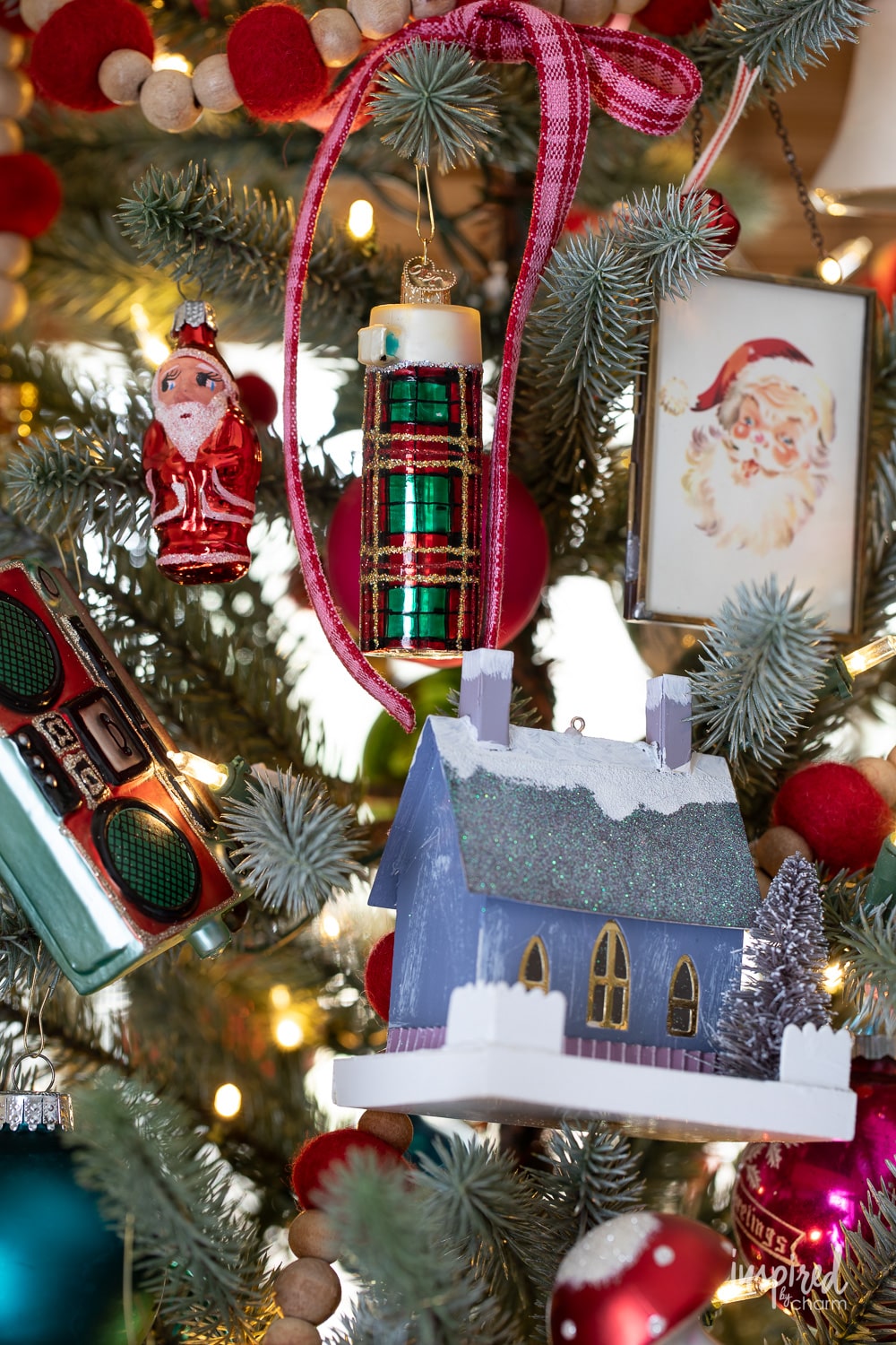 variety of colorful christmas decorations and ornaments hung on a tree.