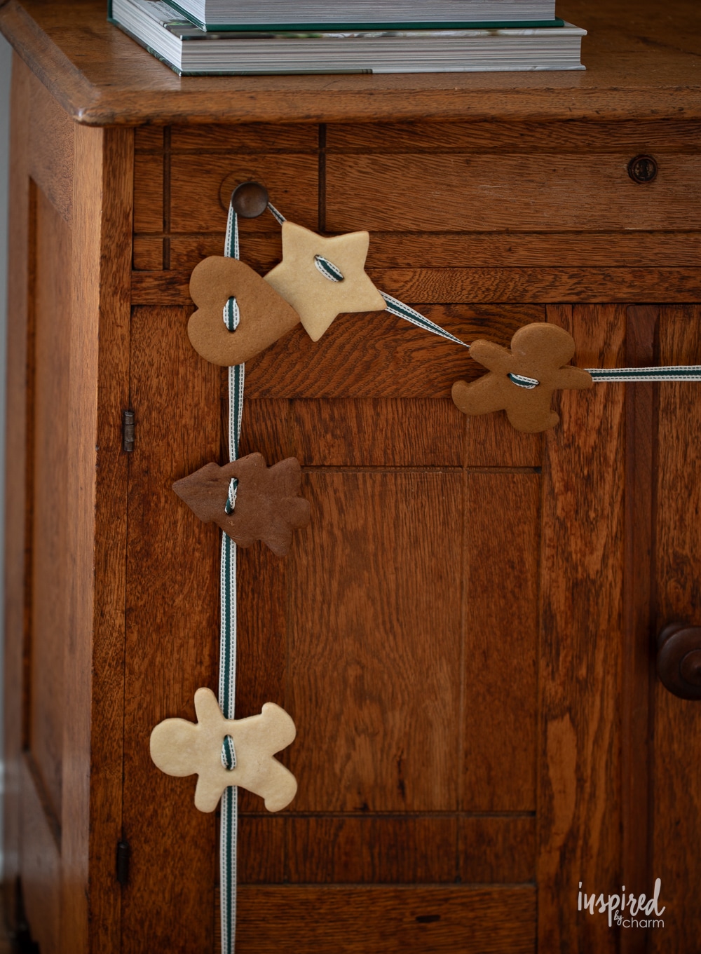 cute gingerbread cookie garland hung on wood cabinet.